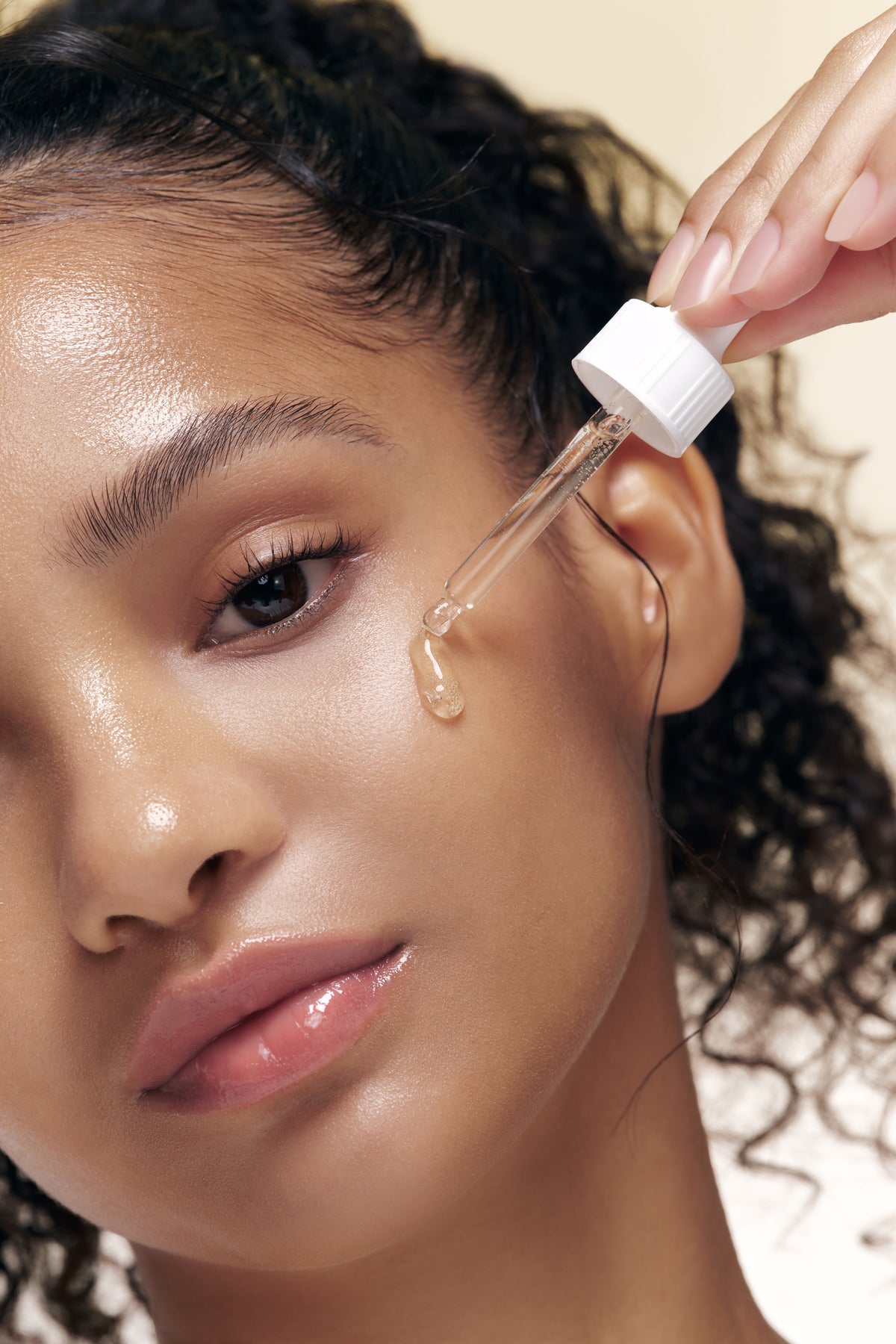 a woman applying a dropper on her face