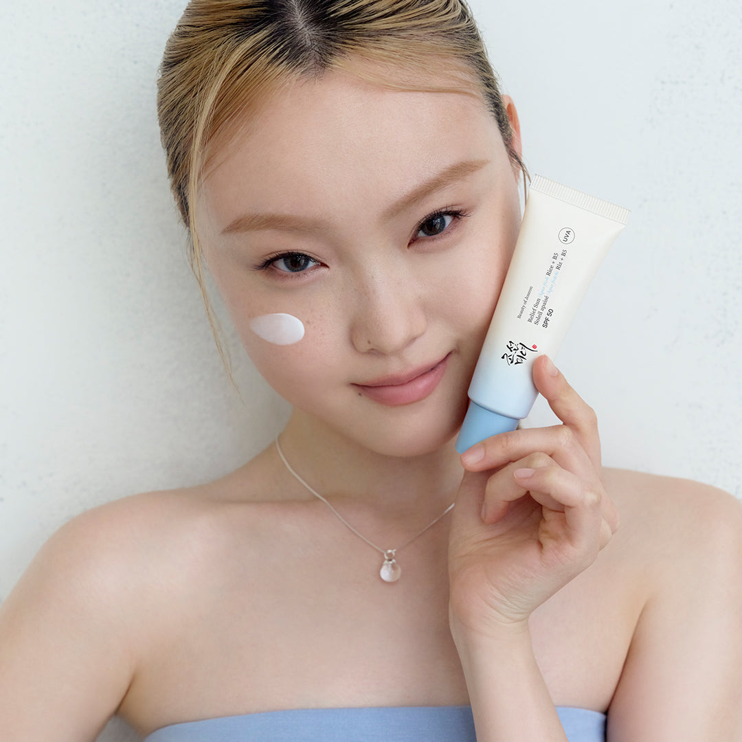 a woman holding a tube of cream
