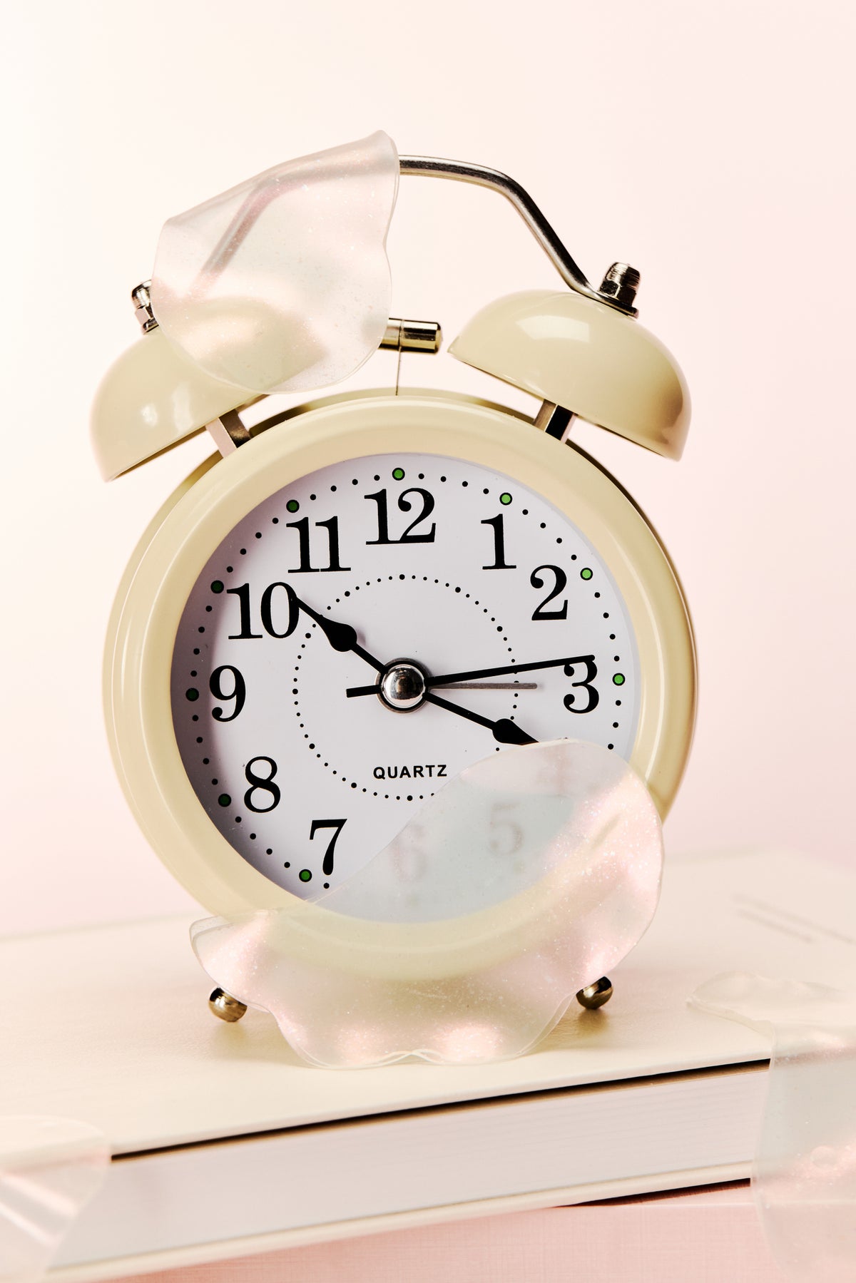 a white alarm clock with a couple of glass pieces on top